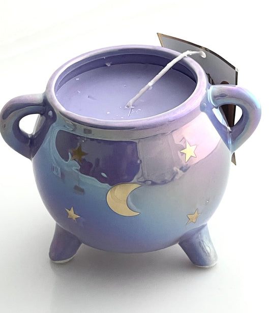 close up of purple cauldron candle with moon and stars